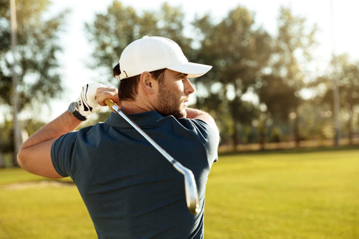 Picture of a man after swinging at a golf ball near the trees