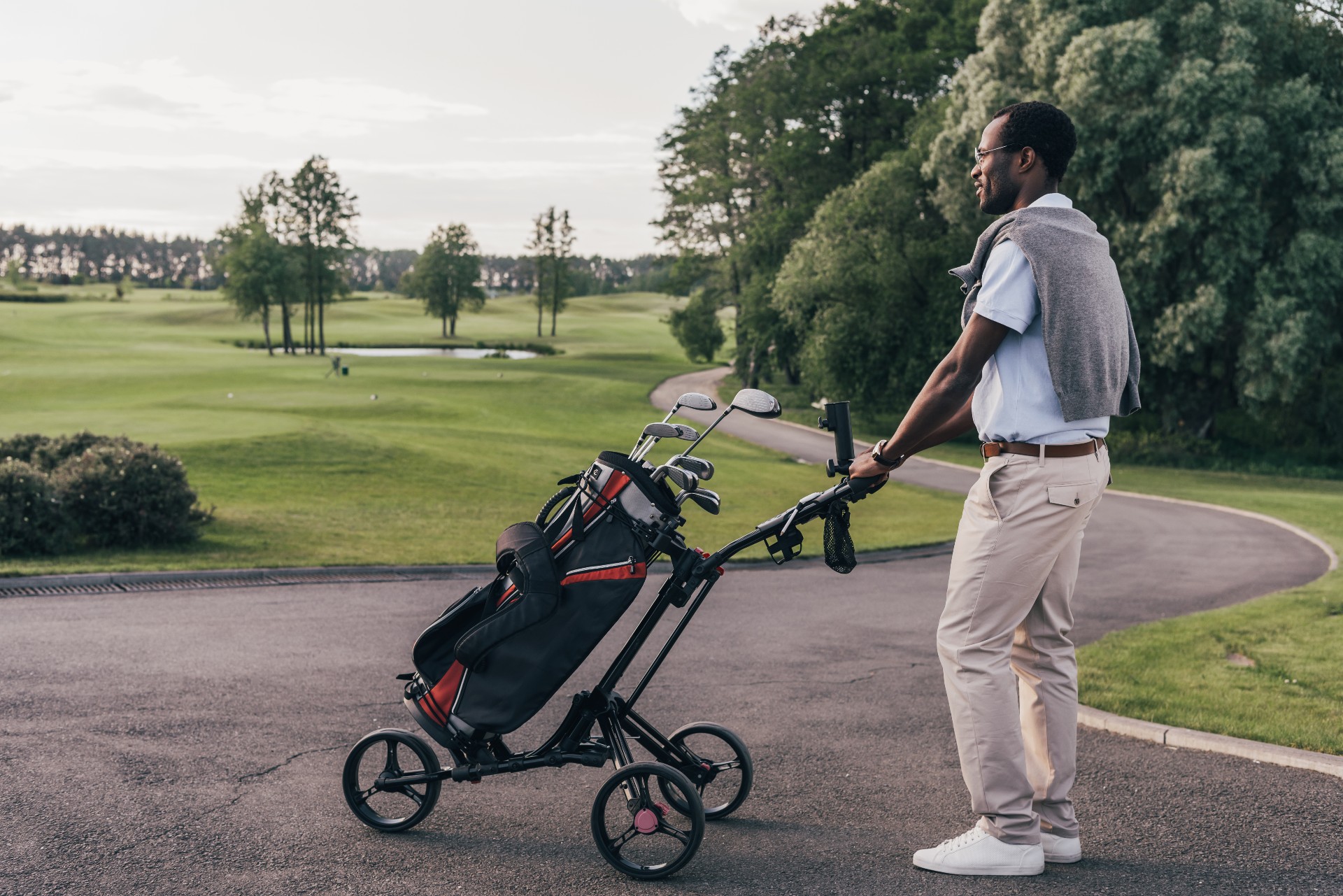 Picture of a man with golf tour bag on a golf course