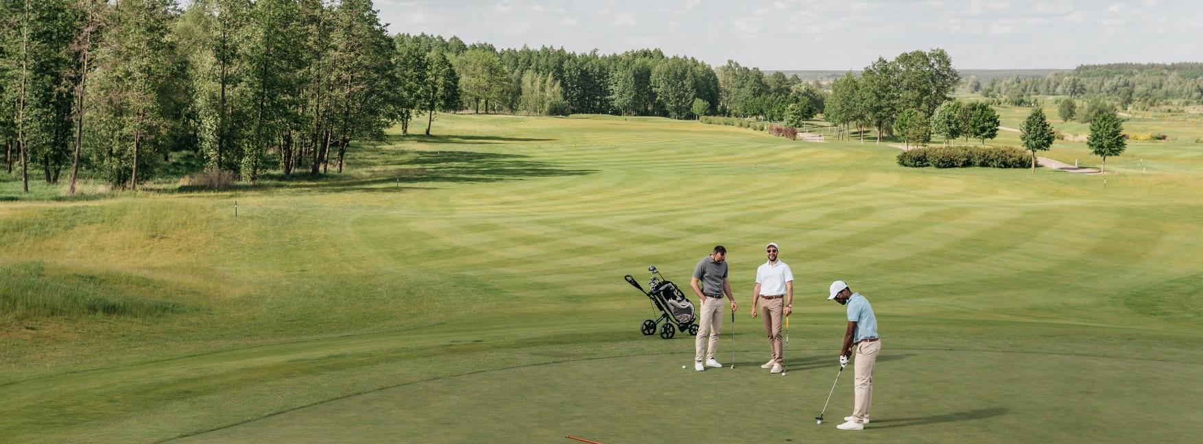 Picture of three golf players on a green playing golf